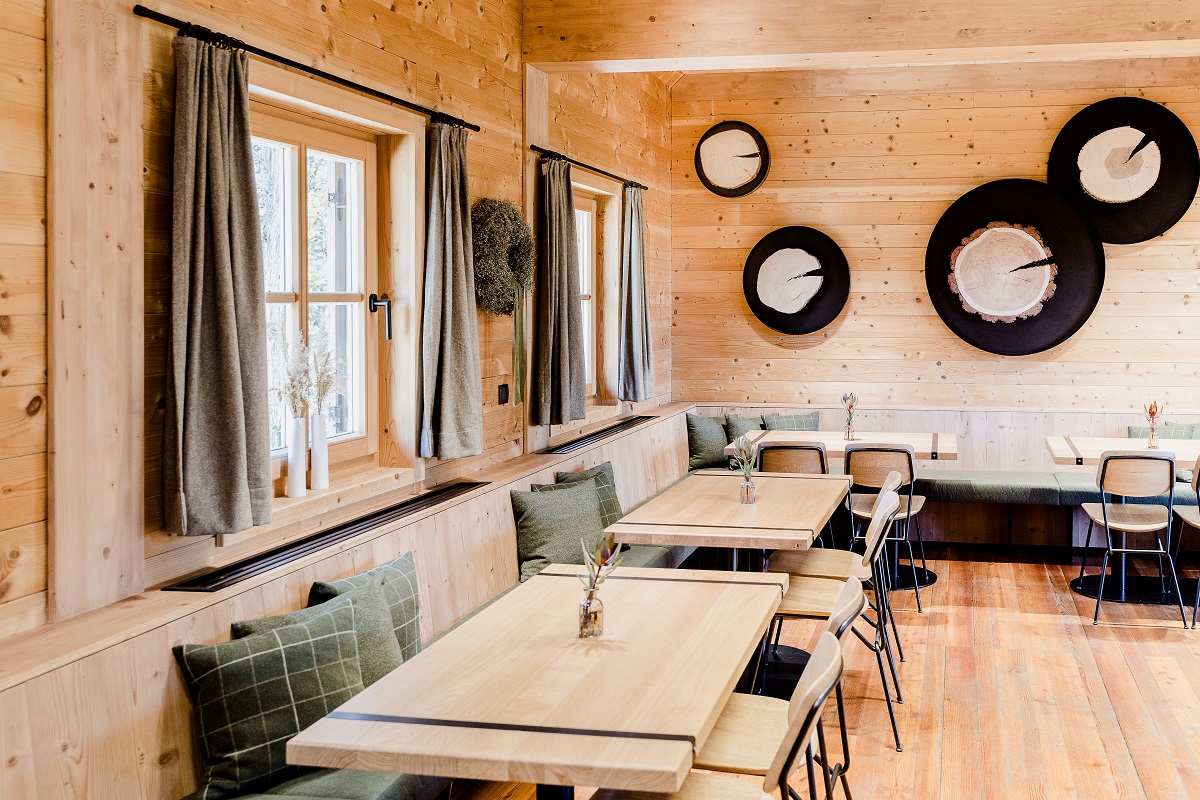Restaurant innen mit Bänken und Pölstern, ein Raum aus hellem Holz