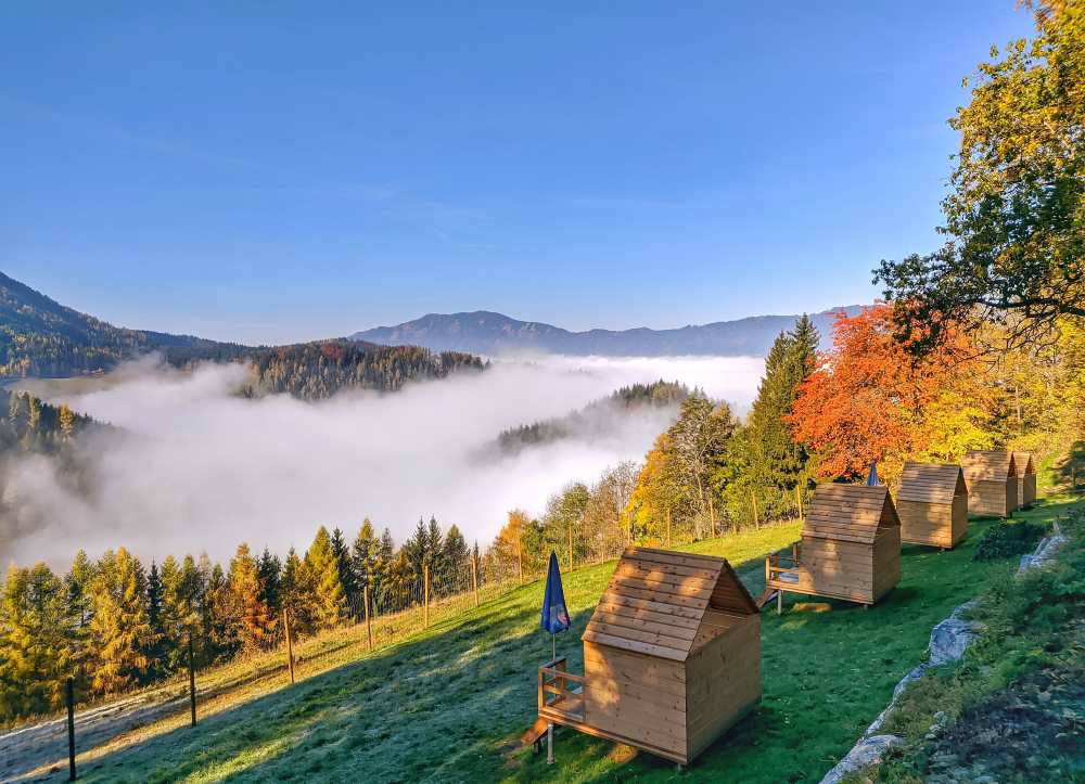 Die Picknickhütten aus Holz mit Aussicht über die Hügel im Morgennebel
