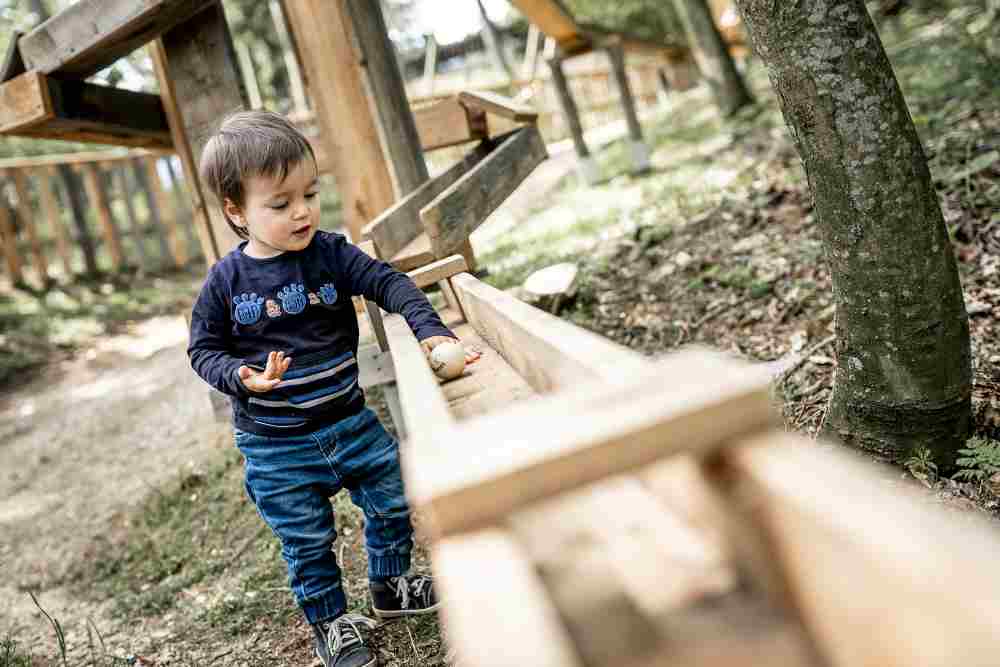Kleinkind spielt mit der Waldkugelbahn.